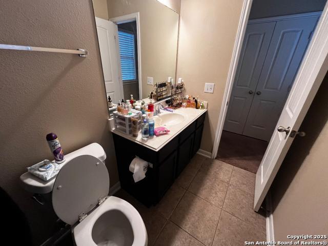 bathroom with toilet, vanity, and tile patterned floors