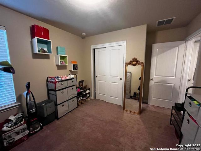 interior space with carpet floors and visible vents