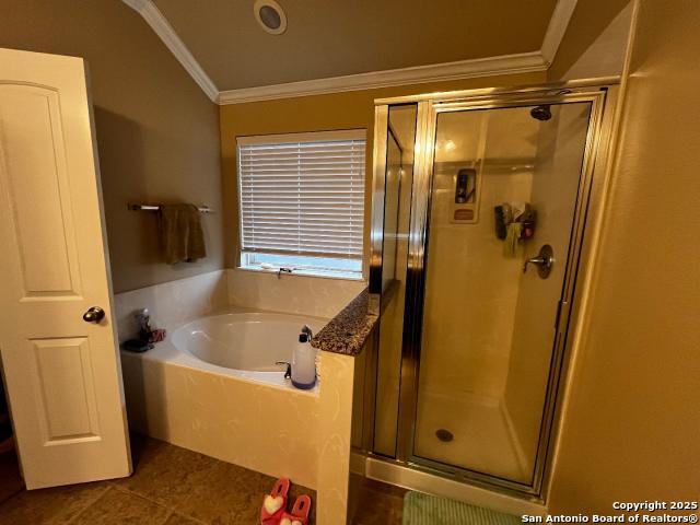 full bathroom featuring a stall shower, a garden tub, and crown molding