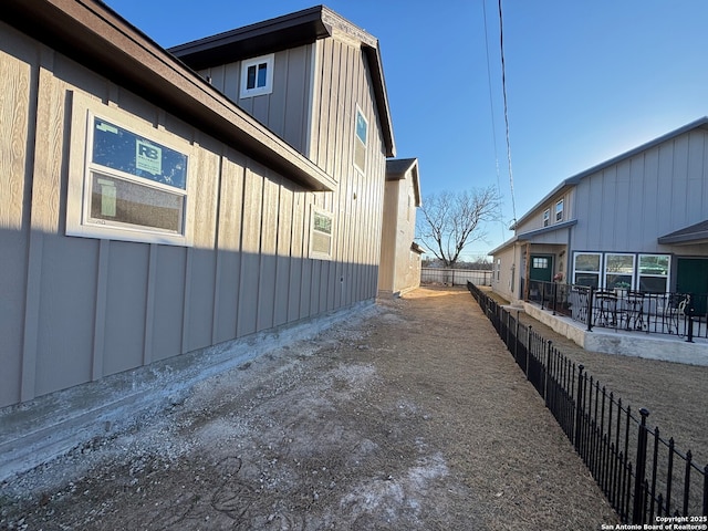 view of property exterior featuring fence and board and batten siding