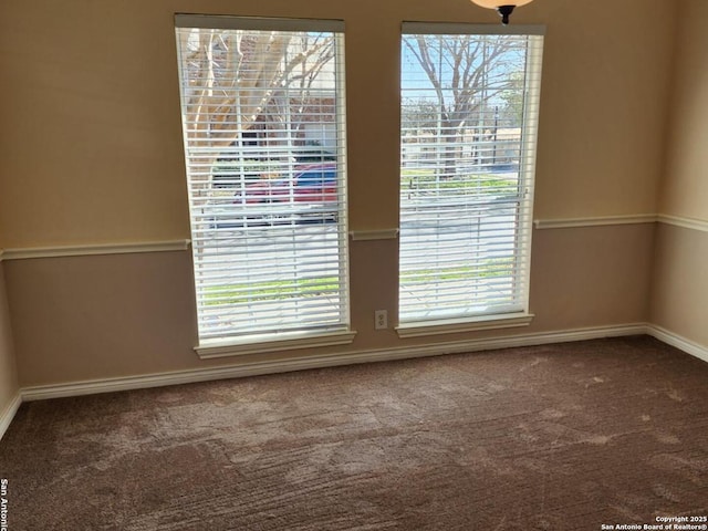 carpeted empty room featuring baseboards