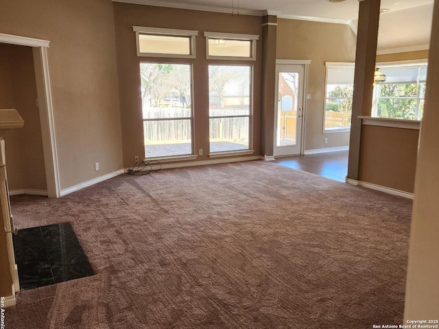 unfurnished room with baseboards, dark colored carpet, and crown molding