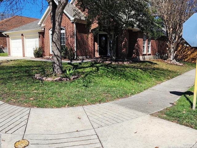 view of front of property featuring a garage, roof with shingles, a front lawn, and brick siding