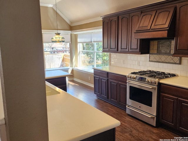 kitchen featuring ornamental molding, dark wood-style flooring, vaulted ceiling, light countertops, and stainless steel range with gas stovetop