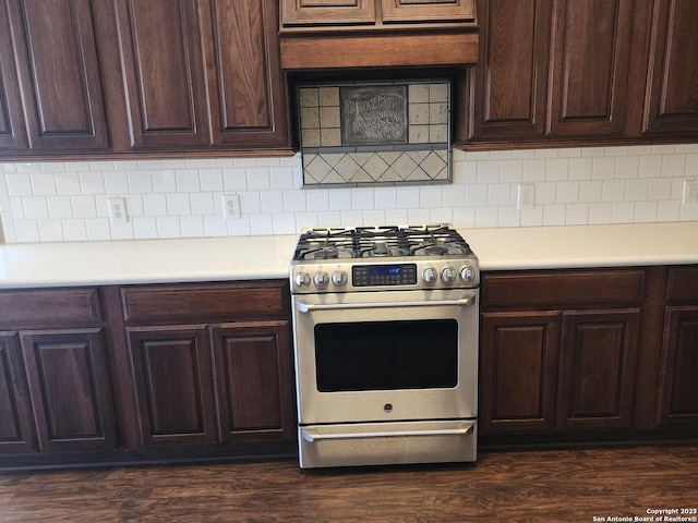 kitchen with dark wood-style floors, light countertops, tasteful backsplash, and stainless steel range with gas cooktop