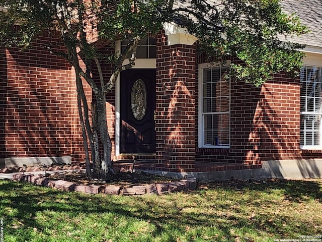 exterior space featuring brick siding and a yard