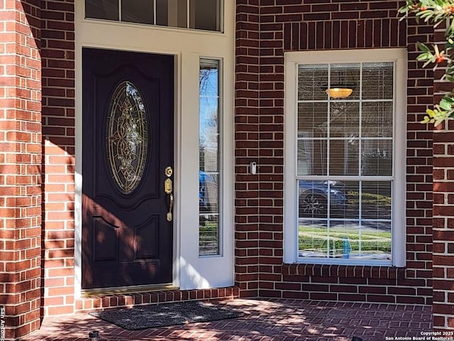 property entrance featuring brick siding