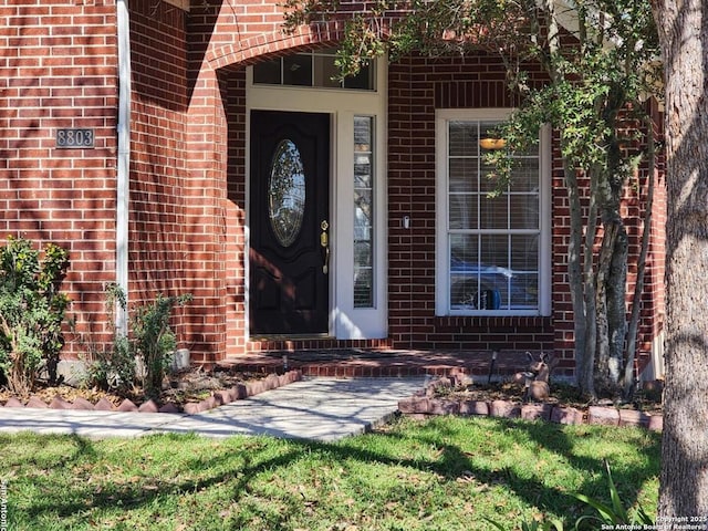 property entrance featuring brick siding