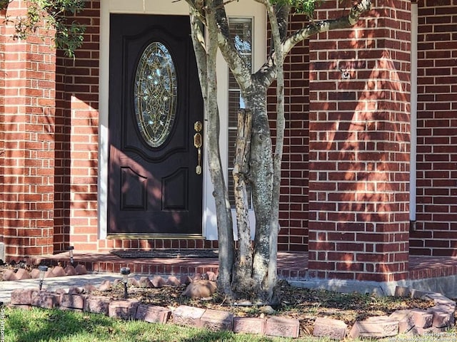 view of exterior entry featuring brick siding