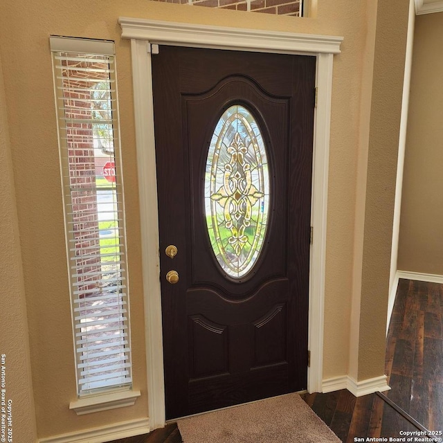 entrance foyer featuring baseboards and dark wood-type flooring