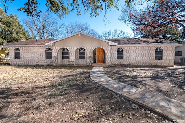 ranch-style home with brick siding and central AC unit