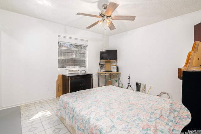 bedroom featuring a ceiling fan, a textured ceiling, and baseboards