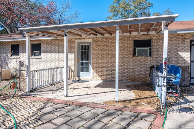 exterior space featuring central AC, a patio, and brick siding