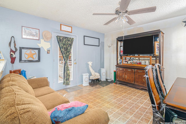 living room with a textured ceiling and ceiling fan