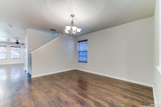 spare room with dark wood-style floors, visible vents, a textured ceiling, baseboards, and stairs