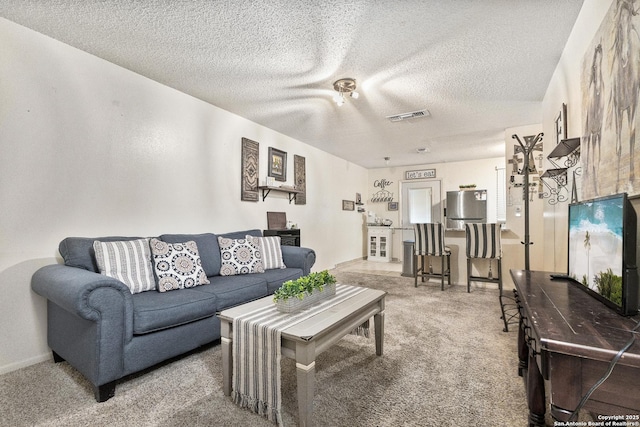 living room with carpet, visible vents, and a textured ceiling