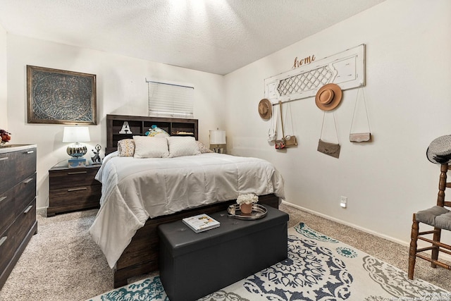 bedroom with light carpet, a textured ceiling, and baseboards