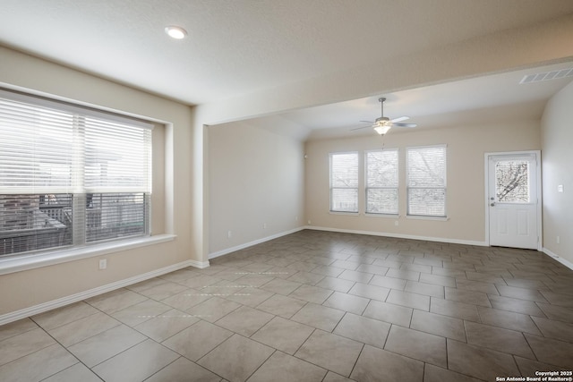 spare room featuring a ceiling fan, a wealth of natural light, visible vents, and baseboards