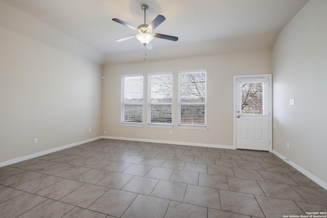 empty room with ceiling fan and baseboards