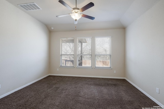 unfurnished room featuring baseboards, visible vents, a ceiling fan, vaulted ceiling, and dark carpet