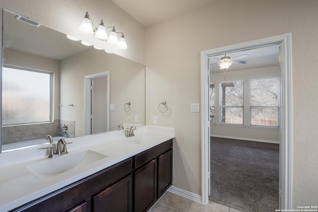 bathroom featuring double vanity, visible vents, a sink, and tile patterned floors