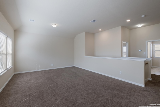 unfurnished room with baseboards, dark colored carpet, visible vents, and recessed lighting