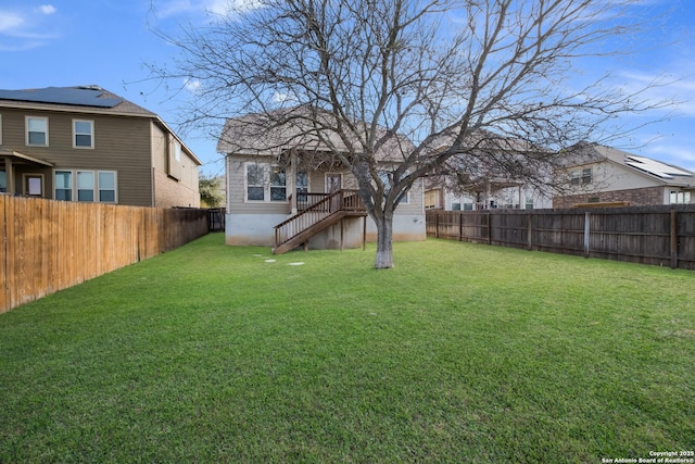 view of yard with a fenced backyard and stairs