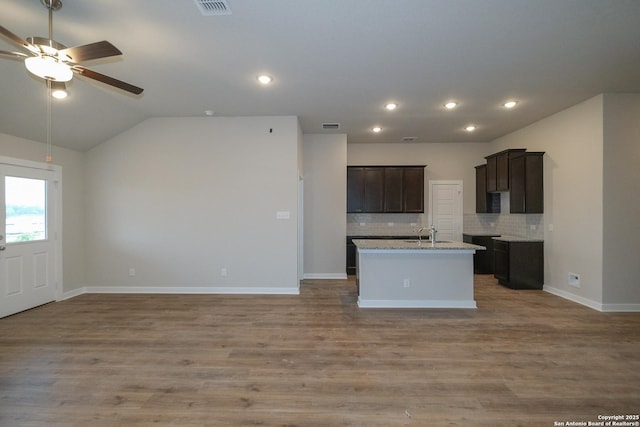 8421 Roadrunner Psge, San Antonio, TX 78222 - kitchen featuring a ceiling fan, open floor plan, backsplash, a kitchen island with sink, and a sink