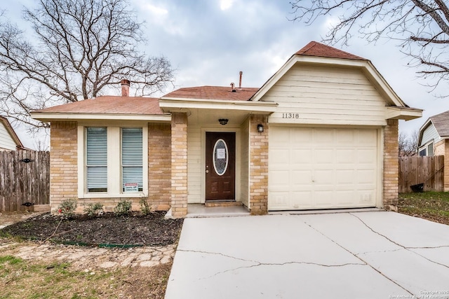 single story home with an attached garage, fence, and concrete driveway