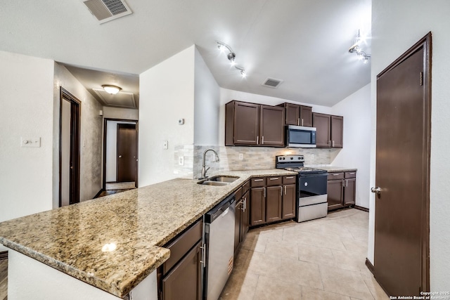 kitchen featuring visible vents, light stone counters, a sink, stainless steel appliances, and backsplash