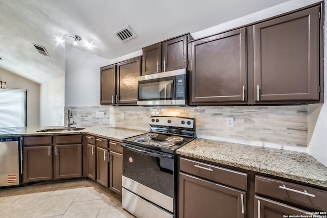 kitchen featuring stainless steel appliances, a sink, visible vents, and dark brown cabinetry