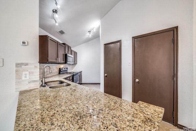 kitchen with visible vents, lofted ceiling, a sink, stainless steel appliances, and backsplash