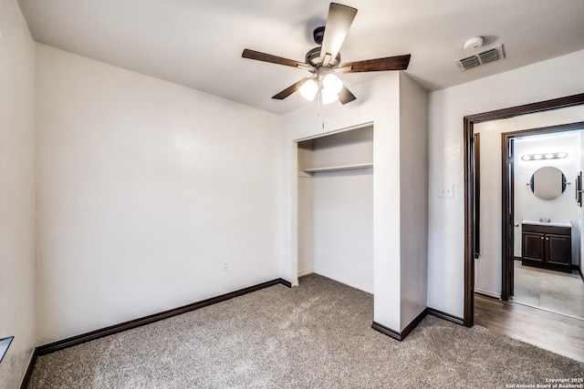 unfurnished bedroom with a closet, baseboards, visible vents, carpet flooring, and a sink