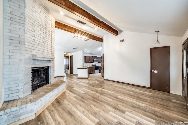 unfurnished living room with visible vents, a fireplace, lofted ceiling with beams, and light wood finished floors