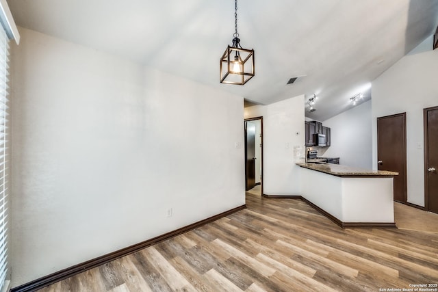 kitchen with visible vents, range, lofted ceiling, light wood-style flooring, and a peninsula