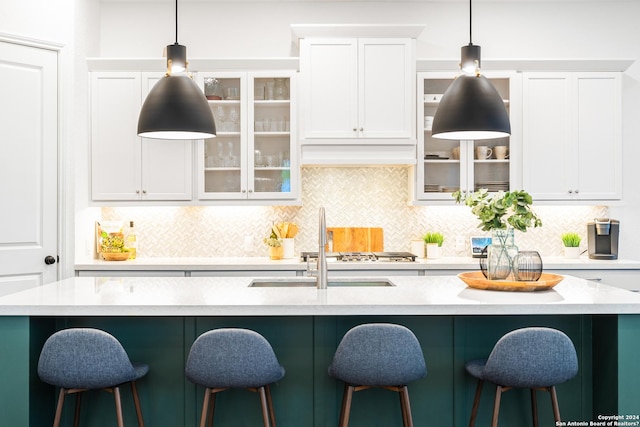 kitchen with an island with sink, glass insert cabinets, and white cabinets