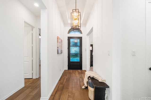 entryway with baseboards, dark wood-type flooring, and a notable chandelier