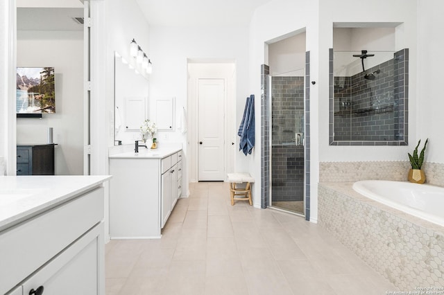 bathroom featuring a garden tub, a shower stall, tile patterned flooring, and vanity