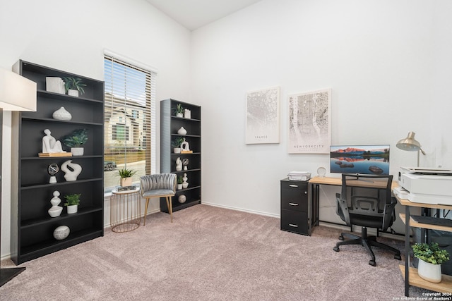 carpeted office space featuring high vaulted ceiling