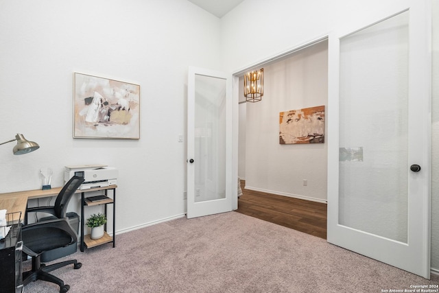 carpeted office space with french doors and a notable chandelier