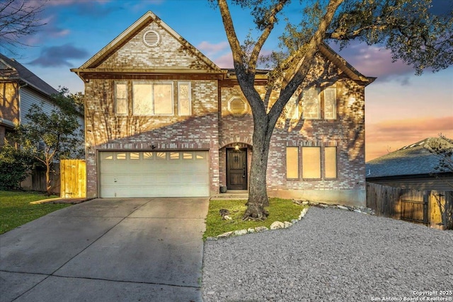 view of front facade featuring a garage, brick siding, driveway, and fence