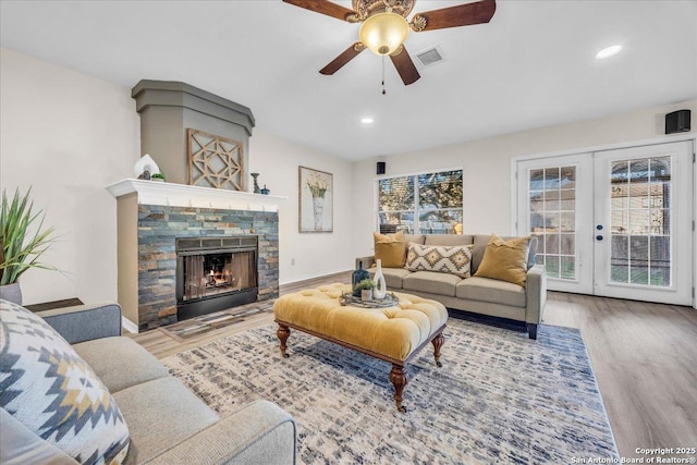 living room featuring a fireplace, visible vents, wood finished floors, and french doors