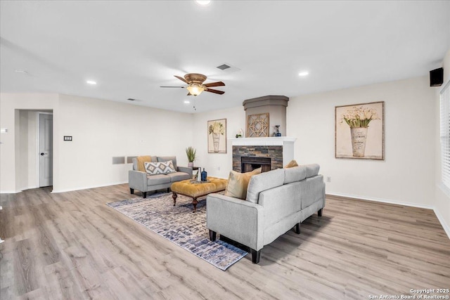 living area with light wood finished floors, a fireplace, visible vents, and recessed lighting