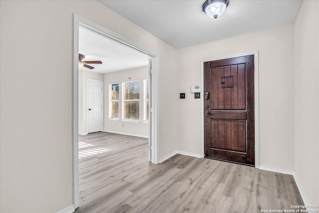 entrance foyer featuring light wood-style floors, baseboards, and a ceiling fan