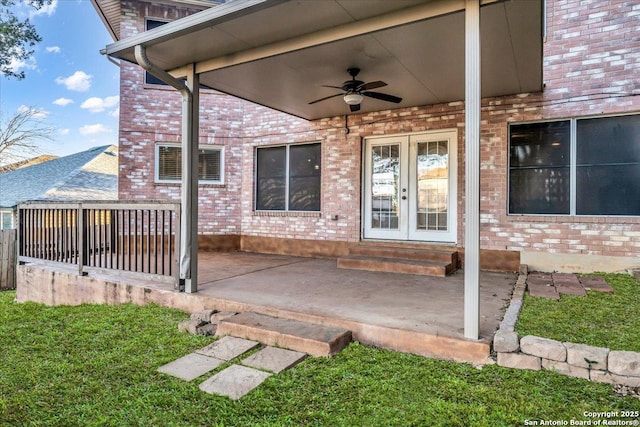 doorway to property with a patio, french doors, brick siding, and a ceiling fan