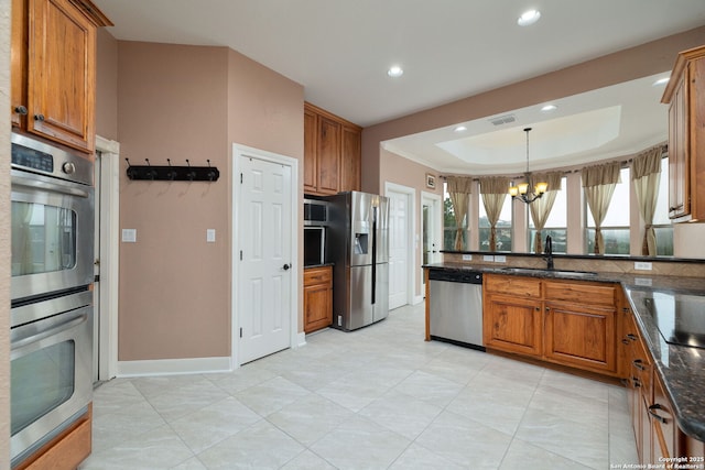 kitchen with appliances with stainless steel finishes, brown cabinets, and a sink