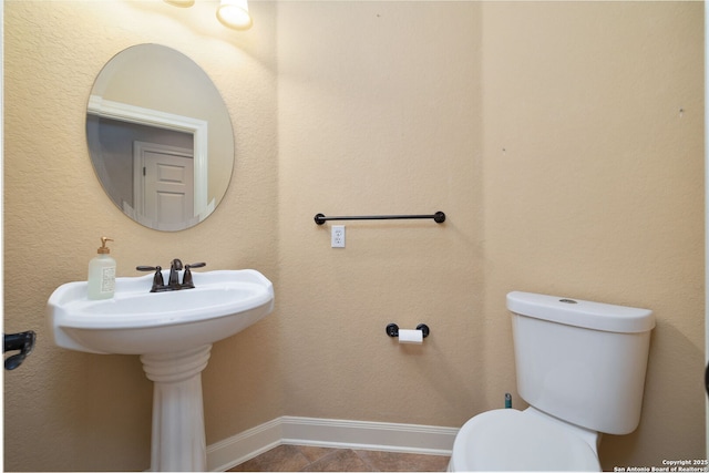 bathroom with baseboards and toilet