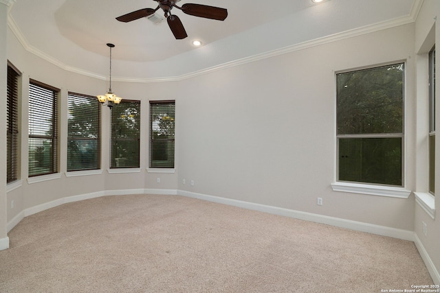 carpeted spare room with recessed lighting, ceiling fan with notable chandelier, baseboards, ornamental molding, and a tray ceiling