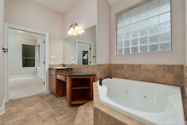 bathroom featuring baseboards, vanity, and a whirlpool tub