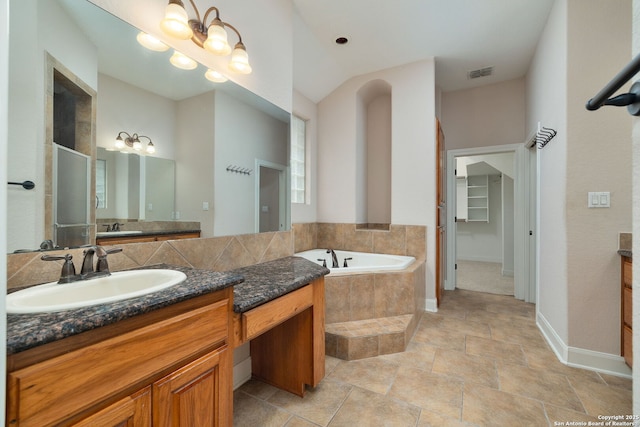 bathroom with visible vents, a garden tub, vanity, and an inviting chandelier